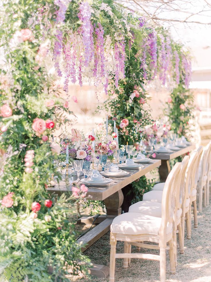 an adorable floral bridal shower with an overhead installation, bright blooms and greenery, blue glasses and candles