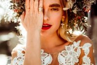 an oversized floral crown with blush, red and white blooms and textural greenery for a fall boho bride