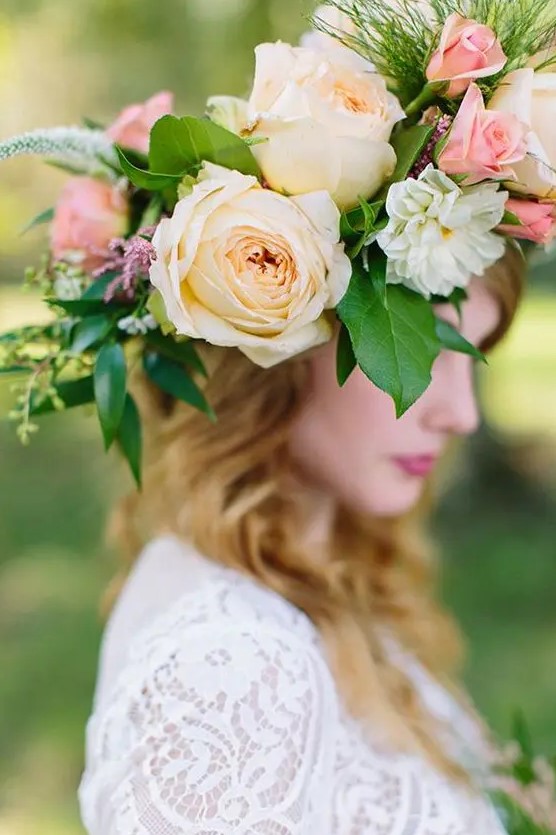 an oversized floral crown with pink and peachy roses, astilbe and much greenery for a midsummer boho bride