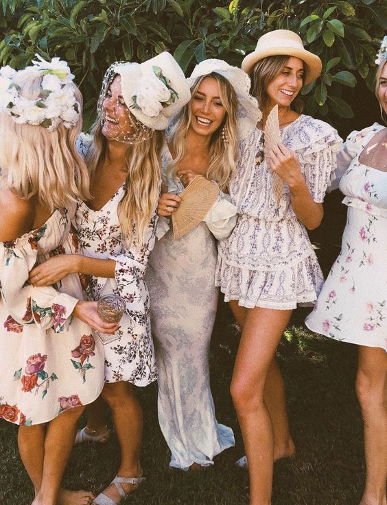 bridesmaids dressed up into floral dresses, cute hats and floral crowns look great at a vintage bridal shower