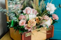 vintage bridal shower decor with vintage suticases, a mirror and neutral and pastel roses and greenery is amazing