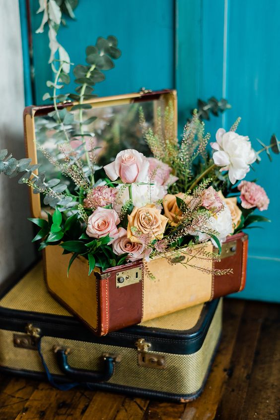 vintage bridal shower decor with vintage suticases, a mirror and neutral and pastel roses and greenery is amazing