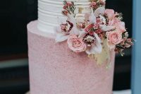 a beautiful and chic wedding cake with a white striped tier, a pink polka dot one, pink and white blooms and greenery is wow