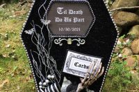 a black glitter coffin with a skeleton hand, blooms, a bow and branches is a great solution for a moody Halloween wedding