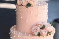 a blush wedding cake decorated with pearls and polka dots, pink blooms and greenery is a beautiful and delicate idea for a spring or summer soiree