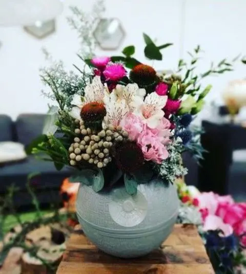 a bright Star Wars wedding centerpiece with a Death Star as a vase and bright blooms and greenery is super bold and cool