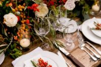 a bright harvest wedding reception with bold blooms, berries and greenery, with neutral porcelain and linens, with berries on each place setting