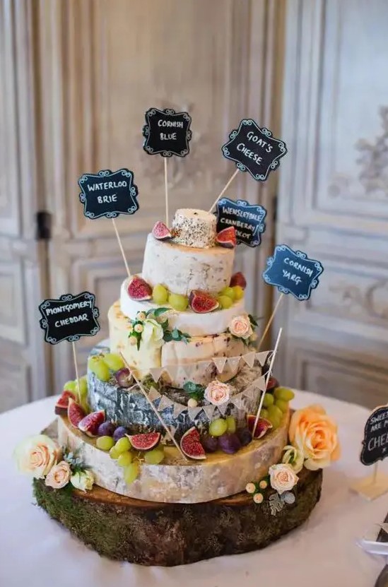 a cheese tower with grapes, figs and toppers to define each type is a great idea for any rustic wedding, and a wood slice helps with that