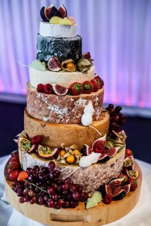 a cheese wheel cake decorated with fresh fruits and berries, with pretty mice meringues is a chic idea for any wedding in summer or fall