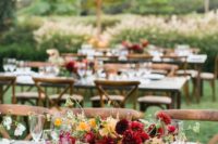 a fall vineyard wedding centerpiece of burgundy, red and marigold blooms and greenery looks fantastic
