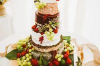 a fantastic cheese wheel wedding cake with fresh grapes, strawberries placed on a palm leaf is an amazing idea for a summer wedding