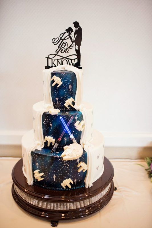 a fun and bold Star Wars themed wedding cake with a space part, space ships, silhouettes and toppers is wow