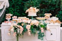 a garden wedding dessert table – a vintage whiet cupboard with greenery and pink flowers and blush sweets