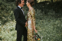 a gold large sequin sheath wedding dress with long sleeves, a high neckline and a tan sheer train just wows