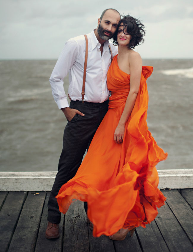 a gorgeous one shoulder orange wedding dress with a draped bodice and a plain skirt, nude shoes and a bold lip for a beach or coastal bride