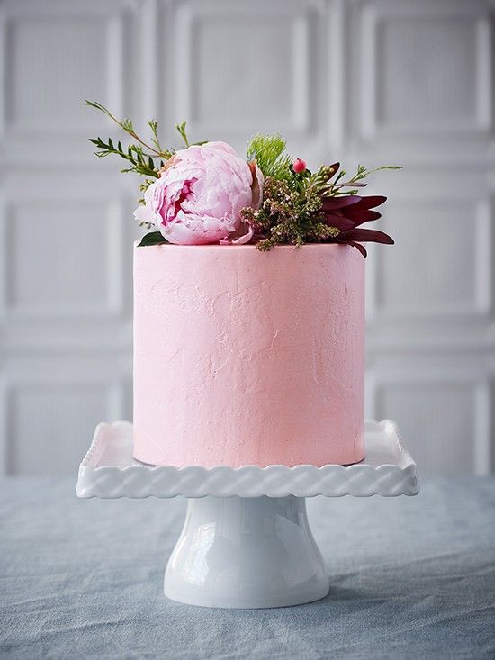 a light pink wedding cake with textural buttercream, a pink peony and usual and dark foliage on top for a summer to fall wedding