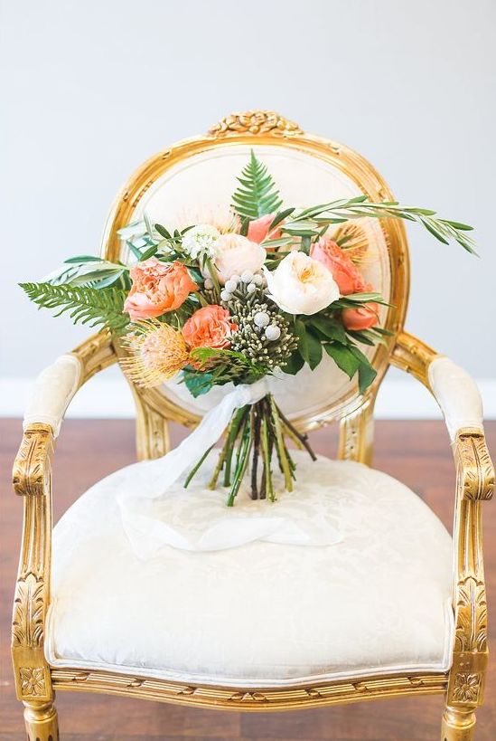 a luxurious beach wedding bouquet with blush and orange blooms, greenery and fronds plus berries is a gorgeous idea