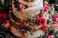 a messy cheese wheel wedding cake topped with orange and hot pink blooms plus herbs is a lovely idea for a boho summer wedding