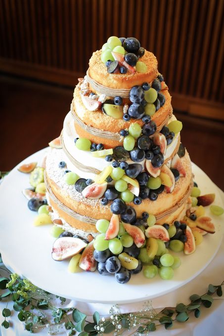 a naked wedding cake topped with grapes, figs and kiwi slices is a creative and cool idea for a vineyard wedding