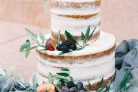 a naked wedding cake topped with greenery, peachies, grapes and blackberries is a cool summer and fall wedding