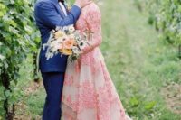 a pink A-line wedding dress with a high neckline, long sleeves, bright pink floral embroidery and a train