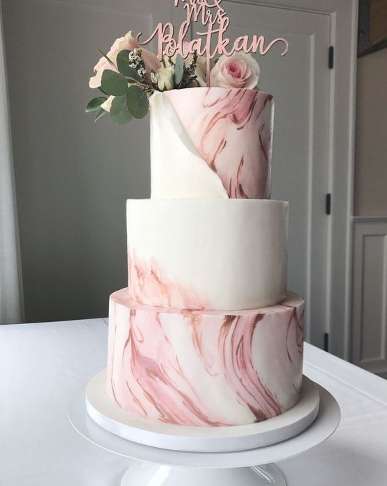 a pink marble wedding cake with a pink calligraphy, blush blooms and greenery is a beautiful and refined idea