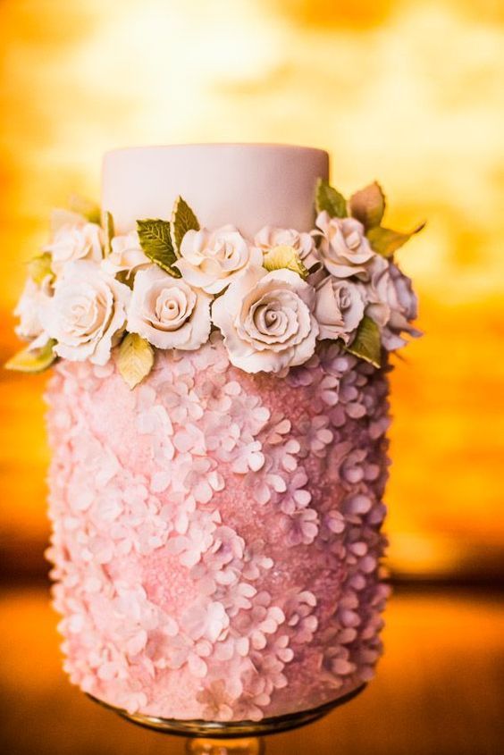 a pink wedding cake with a floral tier, with a sleek one, with pink roses and greenery is a lovely glam idea to rock
