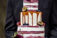 a red velvet partly naked wedding cake with caramel drip, with purple callas and fresh fruit is a decadent idea for a fall vineyard wedding