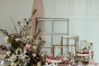 a romantic blush and white dessert table with table runners, a textural greenery and flower arrangement and fresh sweets