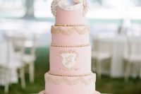 a rose quartz wedding cake with gold detailing and cute bird toppers looks very chic and very romantic