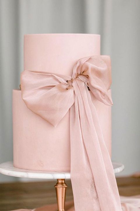 a sleek blush wedding cake with a pink ribbon bow is a stylish and trendy idea as huge bows are a trend of 2022