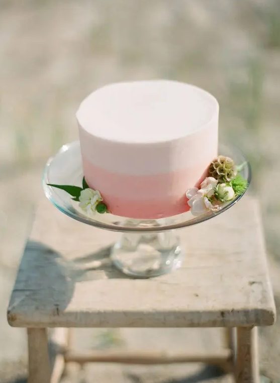 a sleek white and pink color block wedding cake decorated with white blooms and greenery for a modern Valentine wedding