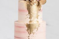 a striped pink wedding cake with gold foil decor, with white and pink blooms, gilded and usual leaves is an elegant and stylish idea