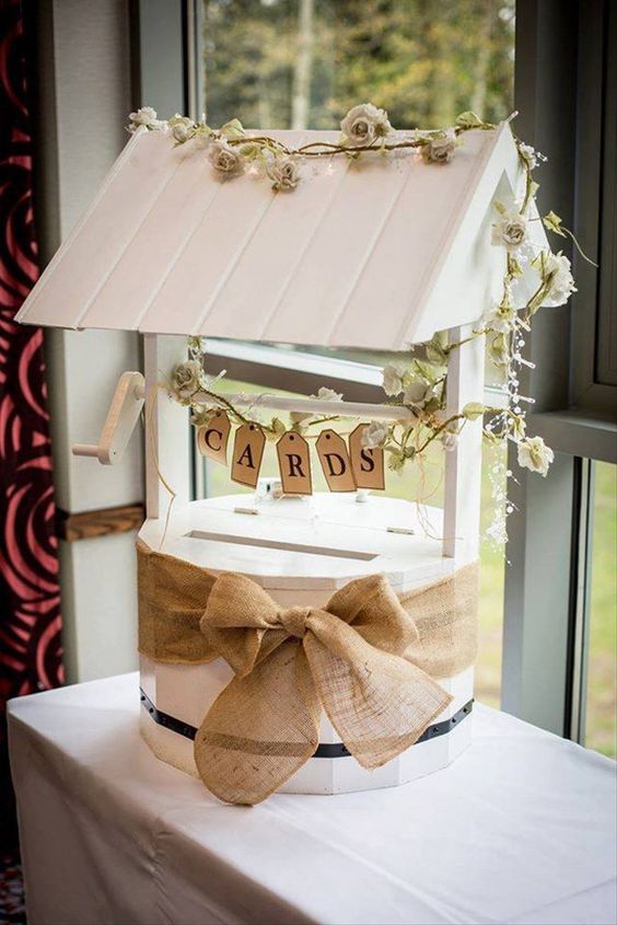 a unique wedding card box styled as a well decorated with burlap, a banner and some vines and blooms is a great idea for a vintage wedding