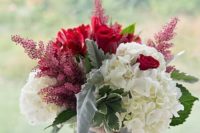 a vase with wine corks, white and red blooms and leaves for a bright summer or fall vineyard wedding