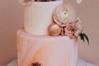 a white and pink marble wedding cake with drip, peachy and blush blooms and glitter macarons is adorable