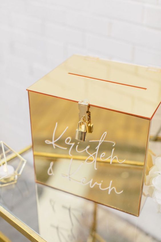 an exquisite glossy gold card box with a lock and calligraphy on it will fit most of modern and glam weddings