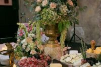 an ideal vineyard wedding cheese table with cheese, berries, salami and nuts plus lush florals for a vineyard wedding
