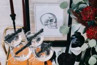 a Halloween bridal shower bar cart with black crystal candies, blackberries and black bottles with alcohol is a lovely idea