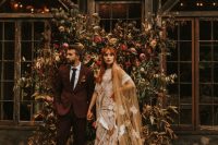 a beautiful fall floral wedding backdrop of greenery, blush and bold blooms plus dried leaves is a gorgeous idea for a fall wedding