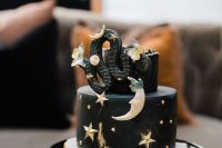 a black celestial Halloween bridal shower or weddign cake decorated with an edible snake and a crescent moon is amazing