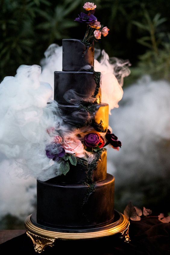 a black wedding cake with geode touches, purple, blush and burgundy blooms and greenery is a fantastic idea for a Halloween wedding