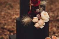 a black wedding cake with neutral, deep red and dark blooms, dried wheat and driedflowers is a lovely idea for a fall boho wedding