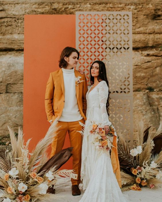 a boho fall wedding backdrop in grey and orange, pampas grass, neutral and rust blooms is idea for a fall wedding