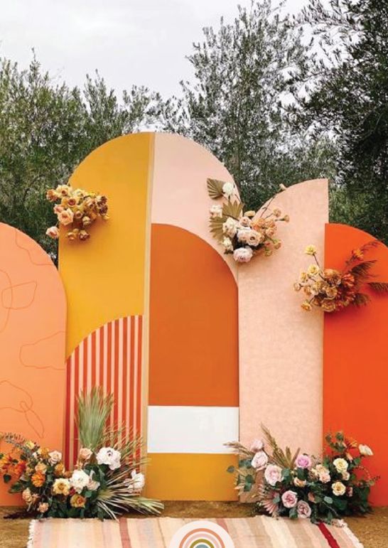 a bold fall wedding backdrop in mustard, blush, orange and white, with pastel and neutral blooms and dried fronds plus pampas grass