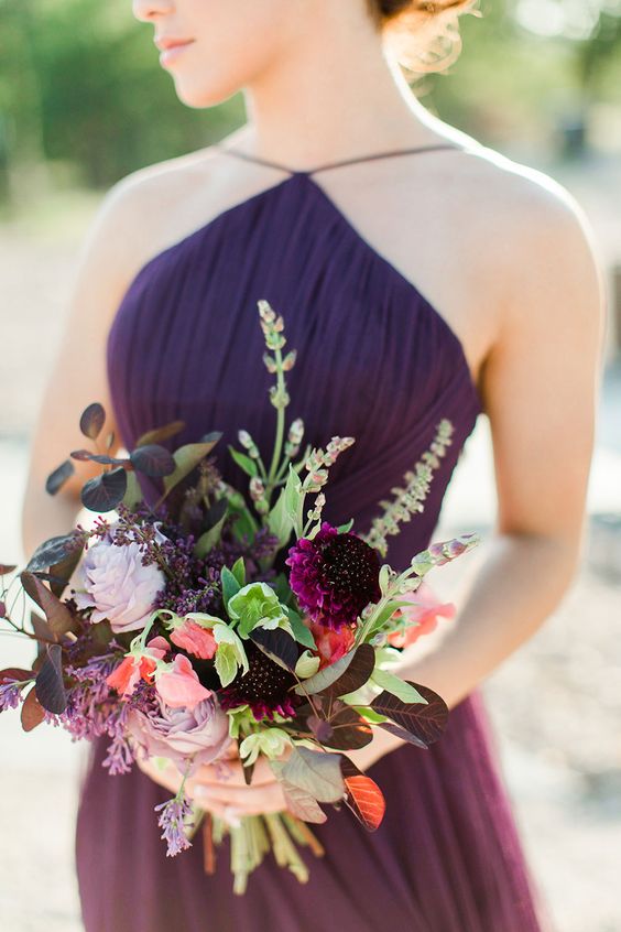 A bold wedding bouquet with plum colored, lilac blooms, greenery and bold leaves for an elegant fall wedding