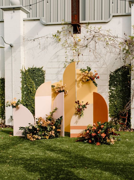 a bright boho fall wedding backdrop in blush, mustard and rust, with bold blooms and greenery is a cool idea to rock