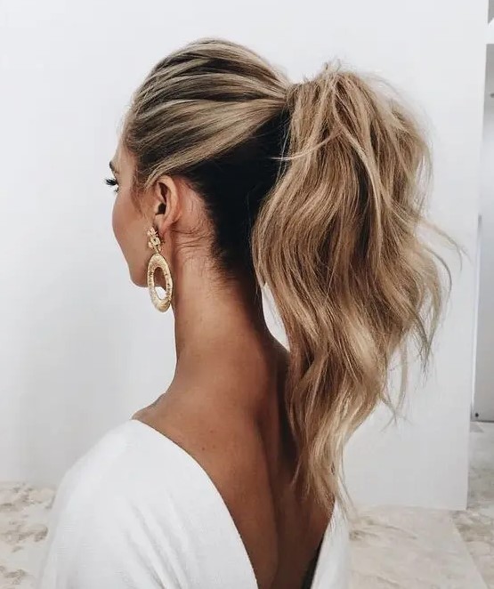 a casual low ponytail with volume on top, texture, dimension and some waves is ideal for a boho or modern bride