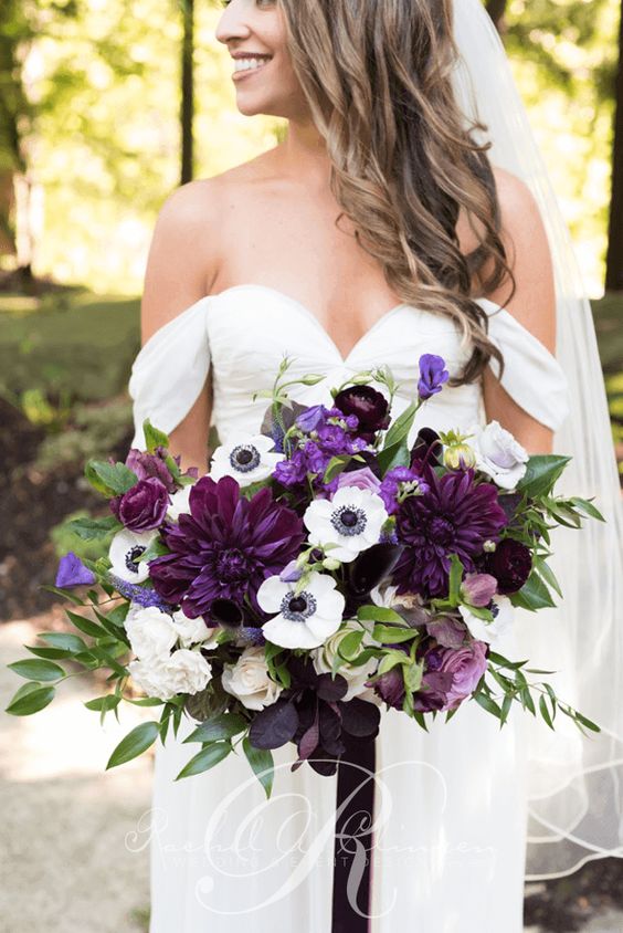 a catchy and contrasting violet, plum and white wedding bouquet with some greenery is a bold statement