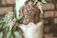 a catchy fall woodland wedding cake that imitates bark and green marble, greenery, succulents and foliage is a cool idea